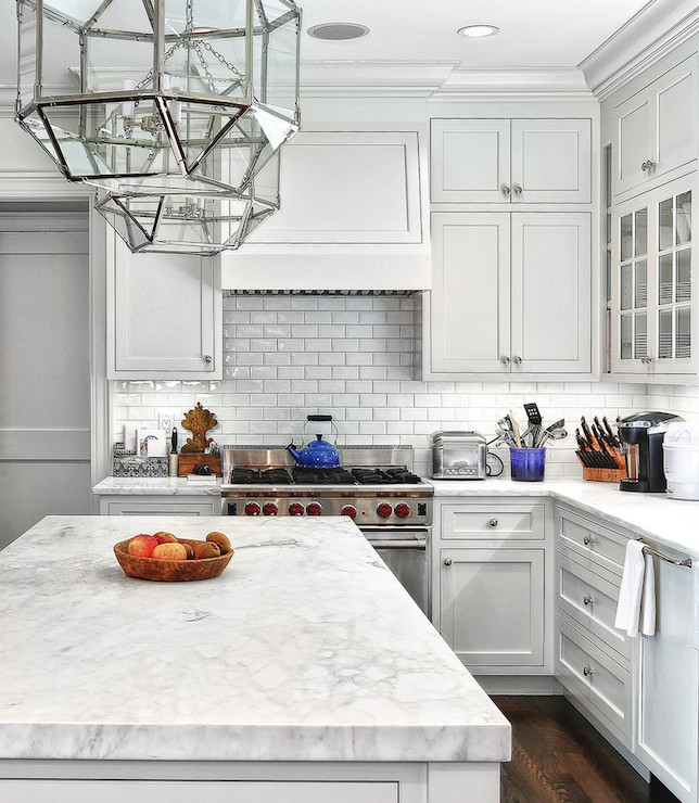 Classic kitchen design with marble countertop and subway tiles - stainless steel stove