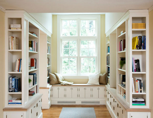 Прекрасная кушетка, расположенная под окном, предлагающая удобное пространство для отдыха в домашней библиотеке