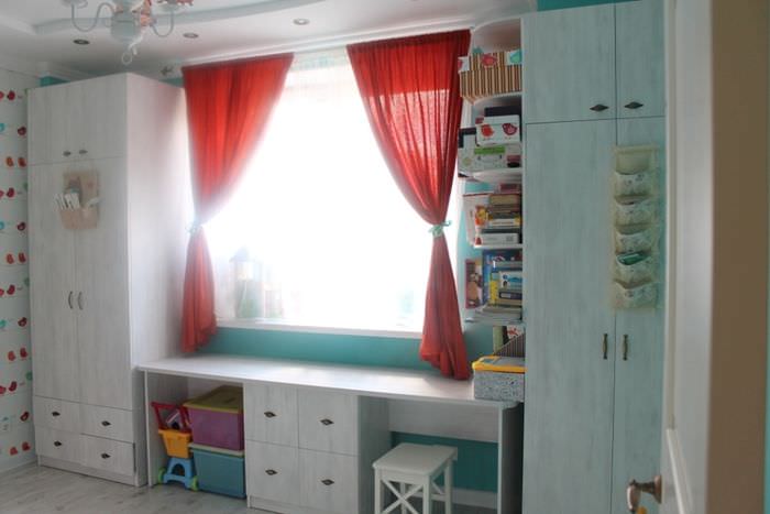 Стол у окна в интерьере детской комнаты