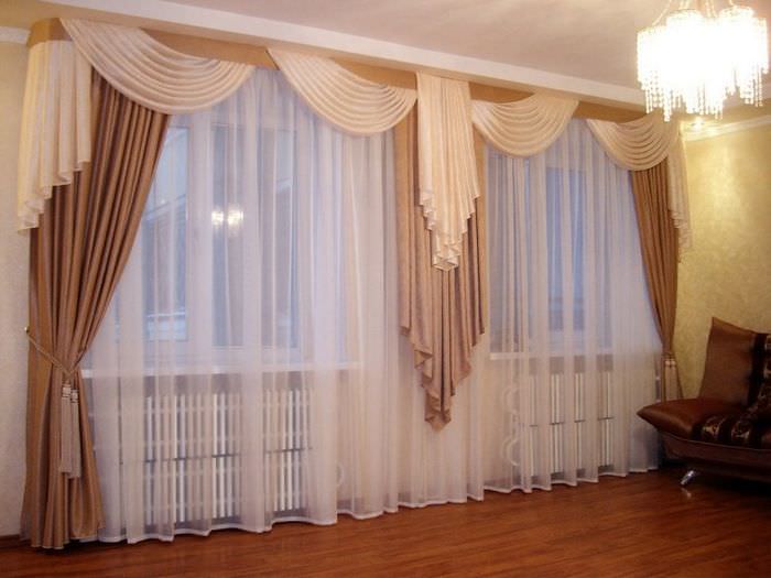 Оформление шторами гостиной с двумя окнами